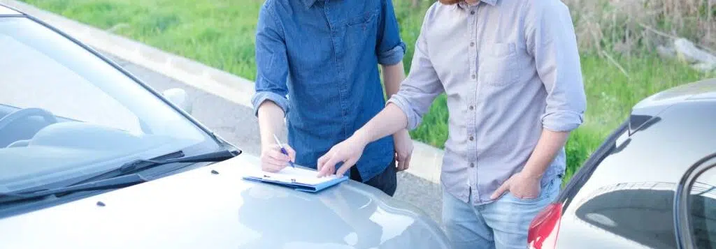 Two drivers exchange contact information following an accident